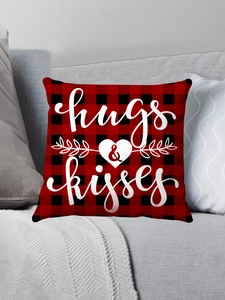 Close-up of red and black buffalo plaid pillow cover with hugs & kisses print on grey sofa