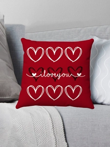 Détail du coussin en peluche rouge avec motifs de cœurs et texte i love you sur canapé