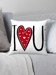 Détail du coussin carré en peluche blanche avec imprimé I Heart U sur un canapé gris