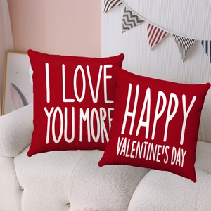 Red Valentine's Day plush throw pillows with I Love You More text on white sofa