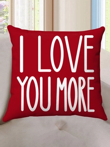 Detail of red plush pillow case with white I Love You More lettering on sofa