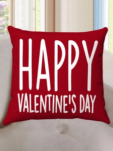 Detail of red Valentine's Day plush pillow with white Happy Valentine's Day text on sofa