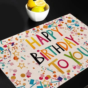 Detailed view of woven Happy Birthday placemat with colorful balloon and star patterns