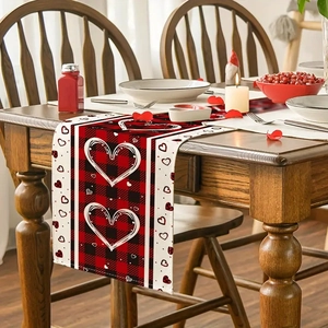 Détail d'un chemin de table en lin à carreaux rouges et noirs avec motif cœur décoratif
