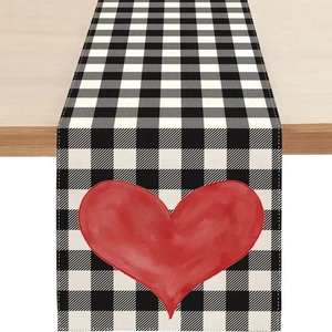 Détail du chemin de table en lin avec motif à carreaux et impression de cœur rouge