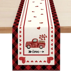 Détail d'un chemin de table en lin avec camion rouge, cœurs et bords à carreaux