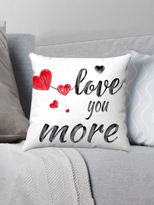 Close-up of Love You More plush pillowcase with red hearts on a gray sofa in cozy setting