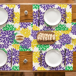 Detailed top view of floral linen placemats with purple dahlias on a dark wood table