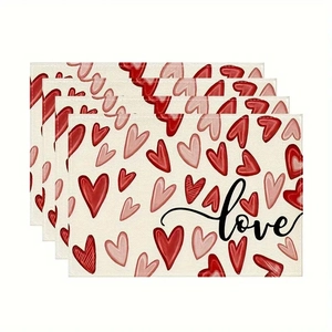 Close-up of four linen placemats with red heart patterns and love calligraphy art