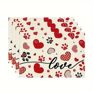 Close-up of linen table mats with red hearts and paw prints showing neat stitched edges