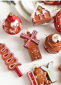 Detail of resin gingerbread ornaments showing creamy frosting textures and golden hooks