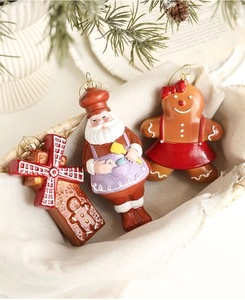 Three festive Christmas ornaments including a gingerbread man and Santa in a cozy basket