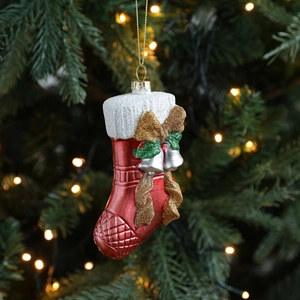 Red and white Christmas stocking ornament with gold bow and silver bells on tree