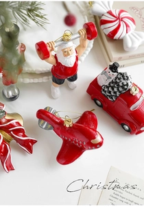 Detalle de adornos de Papá Noel y figuras pintadas a mano en mesa blanca festiva