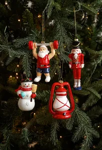 Detalle de adornos de Papá Noel, cascanueces y muñeco de nieve colgados en el abeto
