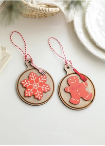 Dettaglio di decorazioni natalizie in legno con motivi a fiocco di neve e omino di pan di zenzero