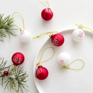 Palline di Natale in vetro rosse e bianche con scritte Merry e Joy su sfondo bianco