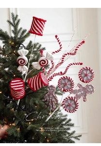 Detail of Christmas candy picks with gingerbread man and lollipop on a glowing tree