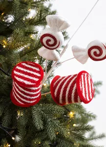 Macro detail of red and white candy cane and lollipop ornaments with glitter on tree