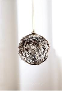 Close-up of champagne gold glitter ball ornament with metallic sequins for Christmas