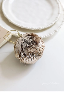 Detailed view of a champagne gold fringe Christmas ball ornament with a hanging loop