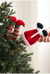 Detail of plush Christmas elf leg sticks and striped picks on a festive Xmas tree