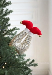 Detailed view of plush red Christmas elf legs with gold bells and sequins for tree decor
