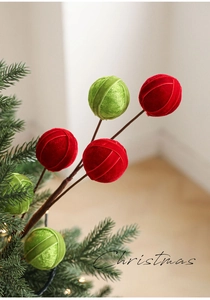Detail of red and green velvet Christmas ornaments on bendable stems for tree decoration