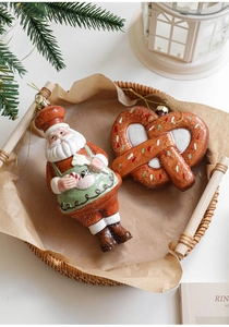 Detail view of festive gingerbread man chef and pretzel ornaments for Christmas tree decor