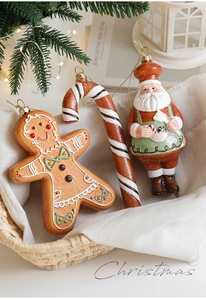 Detailed view of gingerbread man, candy cane and Santa Claus resin ornaments on rustic basket