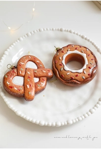 Christmas pretzel and donut ornaments with glitter on a ceramic plate for festive decor