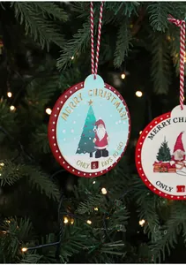 Close-up of wooden Christmas countdown ornament hanging on a festive tree branch