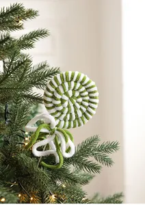 Detail of green and white knit spiral lollipop ornament with bow on Christmas tree