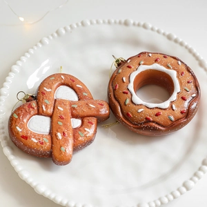Gingerbread pretzel and donut Christmas tree hanging ornaments set on white plate