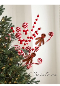 Détail d'un bonhomme en pain d'épices et de sucettes en peluche sur un sapin