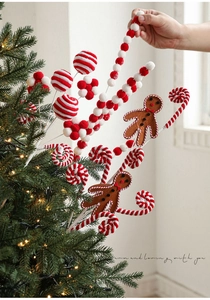 Détail de tiges pour sapin de Noël avec bonhommes de pain d'épices et boules de bonbons
