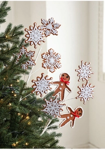 Détails de flocons de neige et bonhommes de pain d'épice décorant un sapin de Noël