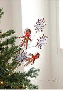 Détail de bonhomme en pain d'épices et flocons en peluche dans un sapin de Noël décoré