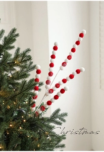 Vue détaillée des boules en peluche rouges et blanches sur branches décoratives de Noël