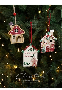 Detail of hand-painted wooden Christmas house ornaments hanging on a lighted tree