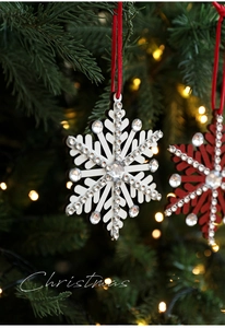 Sparkling snowflake ornaments with crystals and red ropes on a decorated Christmas tree