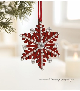 Detail of red snowflake wooden ornament with white rhinestones on a Christmas tree