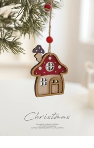 Detail of red mushroom house wooden ornament hanging on a pine tree branch