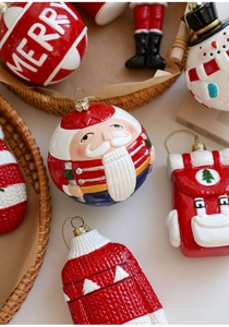 Verschiedene festliche Weihnachtsanhänger mit Weihnachtsmann und Strickwaren im Korb