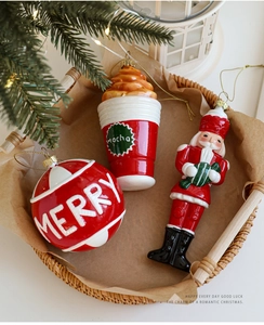 Detailaufnahme von Weihnachtsmann, Christbaumkugel und Mocha-Tasse in einem Korb