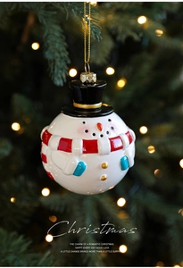 Detailansicht eines Schneemann-Weihnachtsbaumanhängers an Kiefernzweigen mit Bokeh-Lichtern