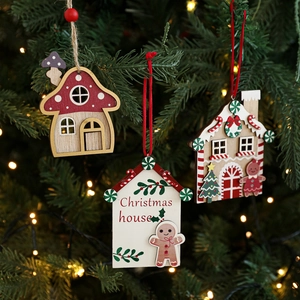 Handcrafted red wooden Christmas house ornaments set hanging on a lit Xmas tree