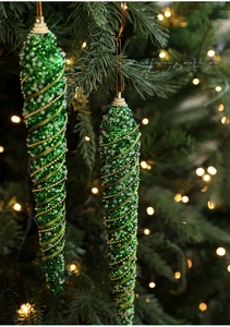 Detail of green spiral Christmas icicle ornament with glitter and gold beads on a tree