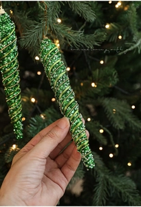 Detailed view of a green glitter spiral icicle ornament with beads for Christmas tree