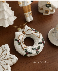 Vue détaillée des ornements de Noël blanc perle avec cordon doré sur bois naturel